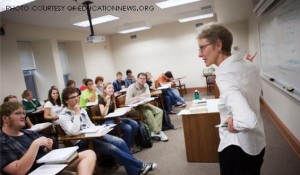 Students listen to a class lecture in a traditional classroom setting.