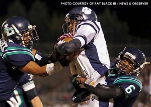 Malcolm Hitchcock and Elisiah Richardson tangle with a Millbrook receiver in the second half.